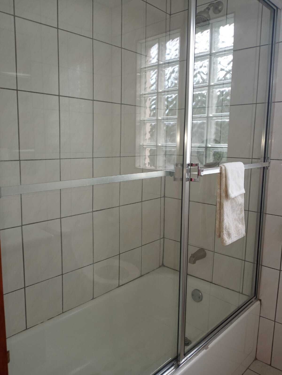 Regadera, secadora de cabello, papel de baño 