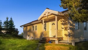 A two-story house with a covered porch, a small front yard, and a pathway leading to the entrance. - Amazing home in Drøbak with kitchen (Drøbak)
