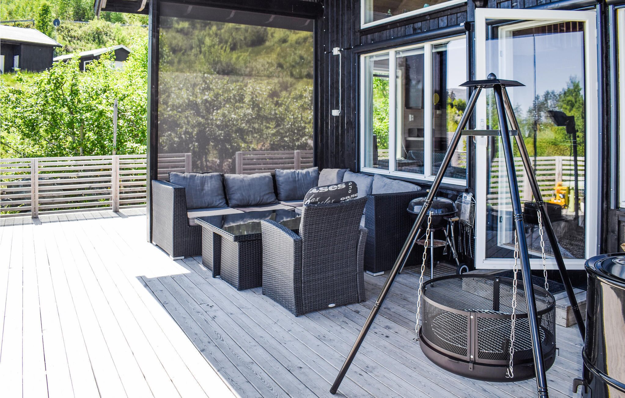 Une terrasse extérieure avec un canapé, des chaises et un espace barbecue.