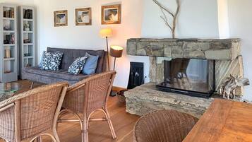 Télévision, cheminée, table de tennis de table, livres