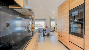 A modern kitchen with a black countertop, wooden cabinets, and built-in appliances.