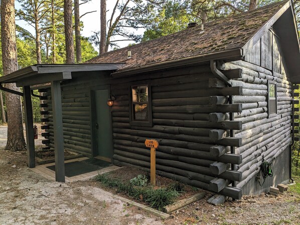 A log cabin with a small porch and a door.