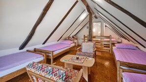 A cozy attic bedroom with three wooden beds, a small table, and a chair. - Stunning home in Samobor (Samobor)