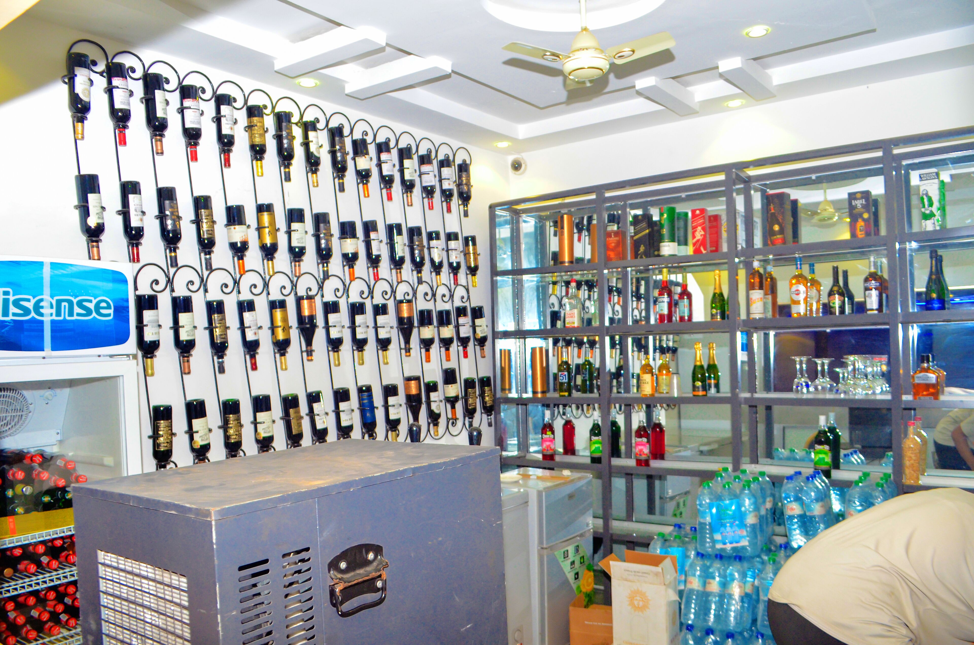 A bar with a wall of wine bottles and shelves of liquor bottles.