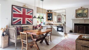 Ein gemütliches Wohnzimmer mit einem Holzesstisch, einer Couch und einer großen Union Jack Flagge.