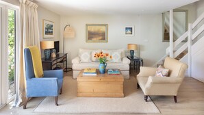 A living room with a sofa, armchairs, a coffee table, and a staircase. - Nest Lodge, a stunning three bedroom lodge surrounded by nature (Pulborough)