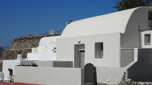 Um edifício branco com parede de pedra e base vermelha.