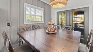 A dining area with a wooden table, wicker chandelier, and a fruit centerpiece. - Our Sweet Little Piece of Tennessee  (Estill Springs)