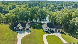 A residential area with two houses, each with a driveway and surrounded by lush greenery. - Our Sweet Little Piece of Tennessee  (Estill Springs)