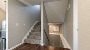 Una escalera con acabado de madera que conduce a un nivel inferior.