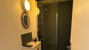 Ein Badezimmer mit Toilette, Waschbecken, Spiegel und Dusche.