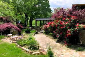 A garden with a stone pathway, a gazebo, and a seating area with chairs. - Tranquil retreat  on 16 acres sleeps 10 guests.  (Mount Pleasant)