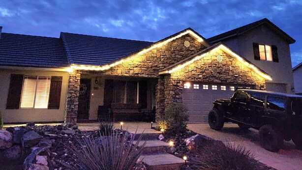 A stone house with a stone chimney, a garage, and a black SUV parked in front. - Zion Happy Retreat- Game Room, Sauna, & workspace! Pet Friendly! (Toquerville)
