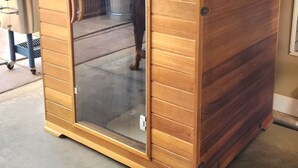 A wooden cabinet with a sliding door, a small window, and a metal container inside. - Zion Happy Retreat- Game Room, Sauna, & workspace! Pet Friendly! (Toquerville)
