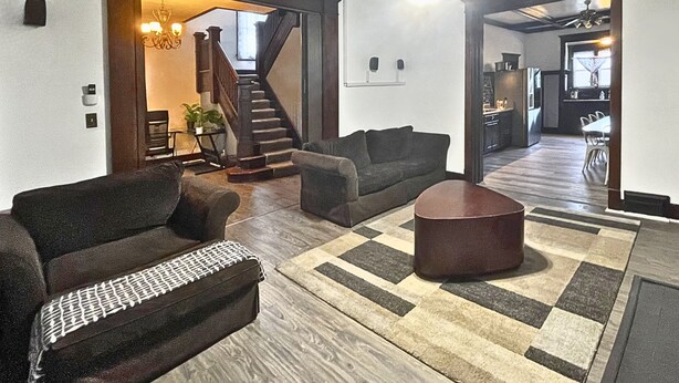 Ein Wohnzimmer mit einer Couch, einem Couchtisch und einer Treppe, die zur Küche führt.
