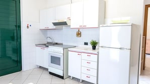A kitchen with white cabinets, a stove, a sink, and a refrigerator. - SE007 - Senigallia, one bedroom apartment on the sea with beach (Senigallia)
