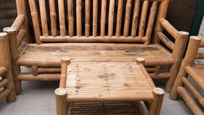 Ein Holzbänkchen und Tisch vor einer Ziegelwand.