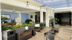 A spacious outdoor lounge area with wicker furniture, potted plants, and a ceiling with skylights. - H.Ixaya (Puerto Vallarta)