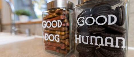 Two glass jars labeled 'GOOD DOG' and 'GOOD HUMAN' containing different snacks.