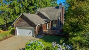 A two-story house with a garage, a covered porch, and a well-maintained lawn.