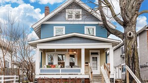 A two-story house with a porch, a chimney, and a large tree in front. - Spacious 4BD 2BA Home Near OSU (Columbus)