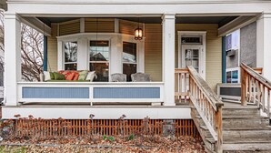A porch with a bench, a wooden staircase, and a door with a number. - Spacious 4BD 2BA Home Near OSU (Columbus)