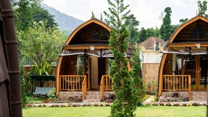 A wooden cabin with a porch and a stone pathway leading to the entrance.