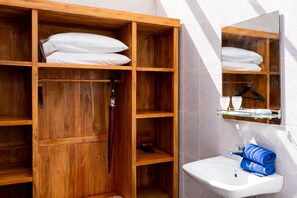 A wooden wardrobe with shelves, a hanging rack, and a mirror. - Kabinku Bali (Baturiti)
