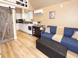 A compact living space with a kitchenette, a sofa, and a dining table. - Hemlock Cabin at Ranger Creek - Near Coalmont OHV Park! (Coalmont)