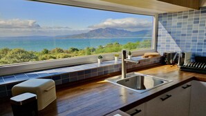 A kitchen with a view of the sea and mountains, a sink, a stove, and a window with a view. - Restored fisherhouse for 6 persons (Lira (Santa Maria))