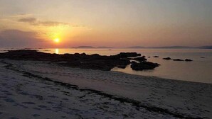 A beach at sunset with rocky formations and calm water. - Restored fisherhouse for 6 persons (Lira (Santa Maria))