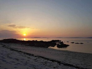 A beach at sunset with rocky formations and calm water. - Restored fisherhouse for 6 persons (Lira (Santa Maria))