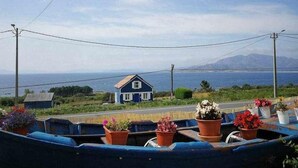A coastal view with a house and a boat docked by the shore. - Restored fisherhouse for 6 persons (Lira (Santa Maria))