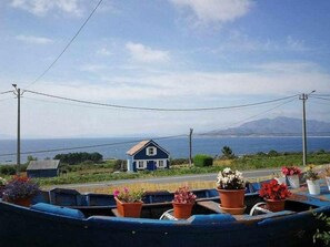 A coastal view with a house and a boat docked by the shore.
