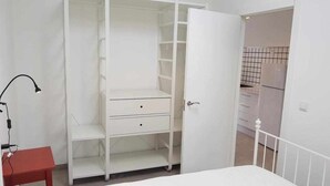A room with a white wardrobe, a red table, and a white bed. - Bungalow n°6 on the Lighthouse Road (Lariño)