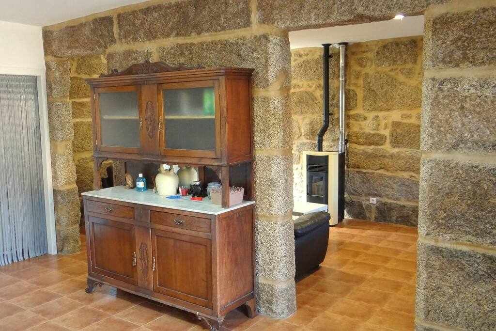 Una habitación con pared de piedra, un armario de madera con puertas de cristal y una chimenea.