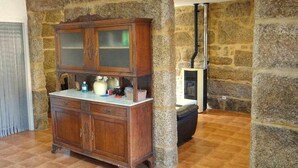 Une pièce avec un mur en pierre, un meuble en bois doté de portes en verre et une cheminée.