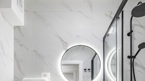 A modern bathroom with a toilet, sink, and shower. - Did' (Split)