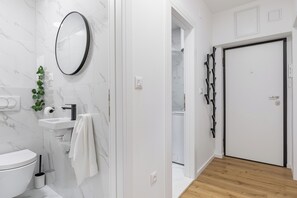 Superior appartement | Badkamer | Een douche, een regendouche, een haardroger, handdoeken