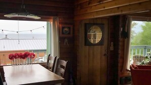 A wooden interior with a dining table, chairs, and a large mirror. - Good Vibes Cabin - Car rental available! (Craig)