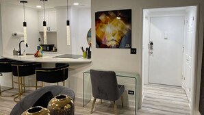 Una cocina moderna con lámparas colgantes, una zona de bar, una silla de comedor y una puerta.