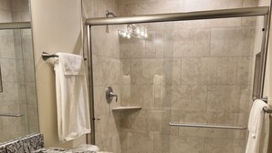 A modern bathroom with a shower, toilet, and vanity.