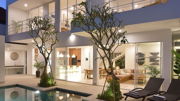 A modern two-story house with a swimming pool, outdoor seating, and a well-lit interior. - Villa Cruz in the centre Berawa (Canggu)
