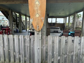 Un espace extérieur abrité, doté d’une clôture en bois, d’un barbecue et de mobilier d’extérieur.
