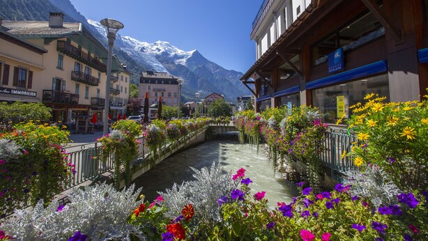 A canal with colorful flowers and a mountain backdrop. - Grand Chalet des Moussoux 6BR: Terrace, Garden, Views, Sleeps 10, Chamonix, France (Chamonix)