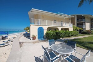A beachfront hotel with a pool area, outdoor seating, and a view of the ocean.