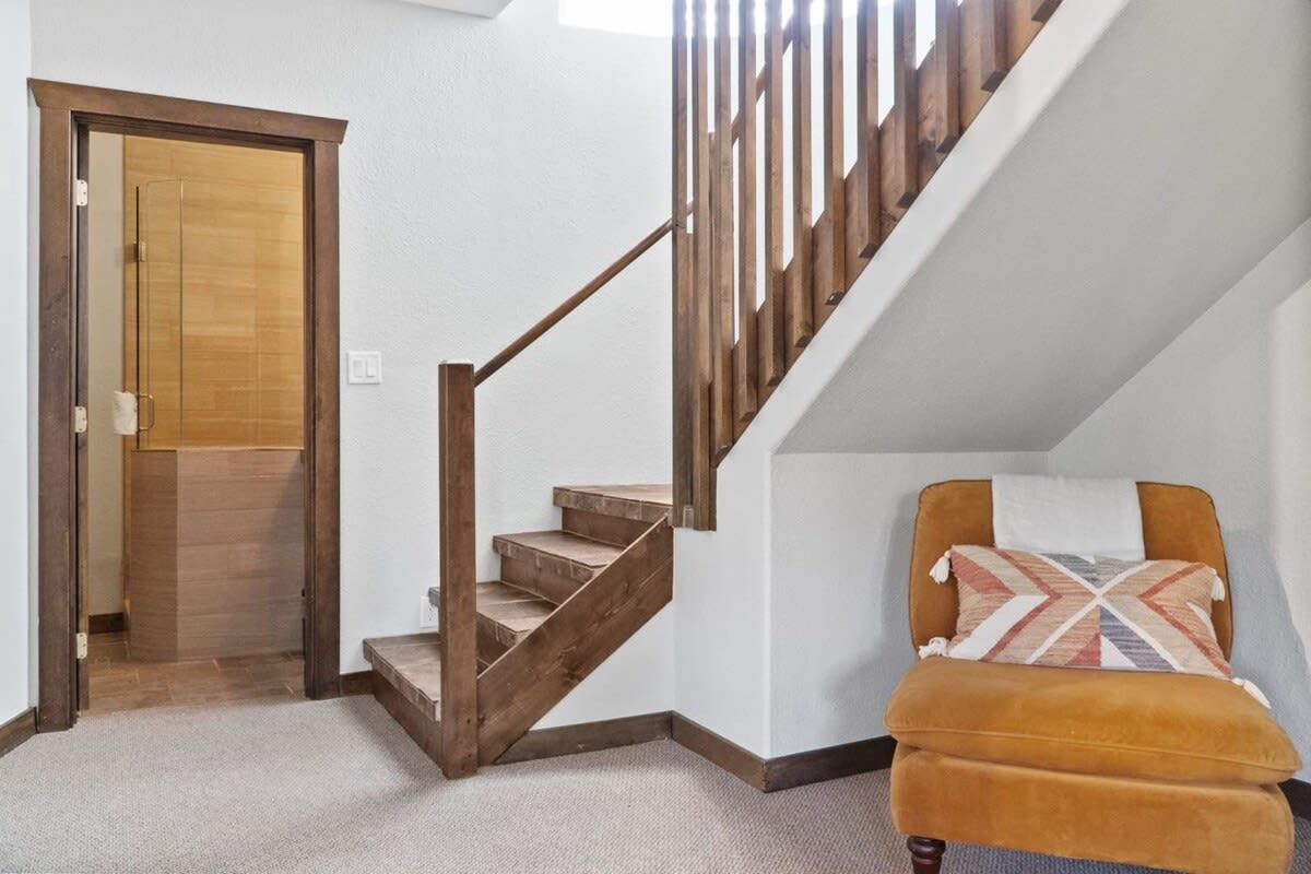A staircase with wooden steps and a wooden handrail leading to a door.