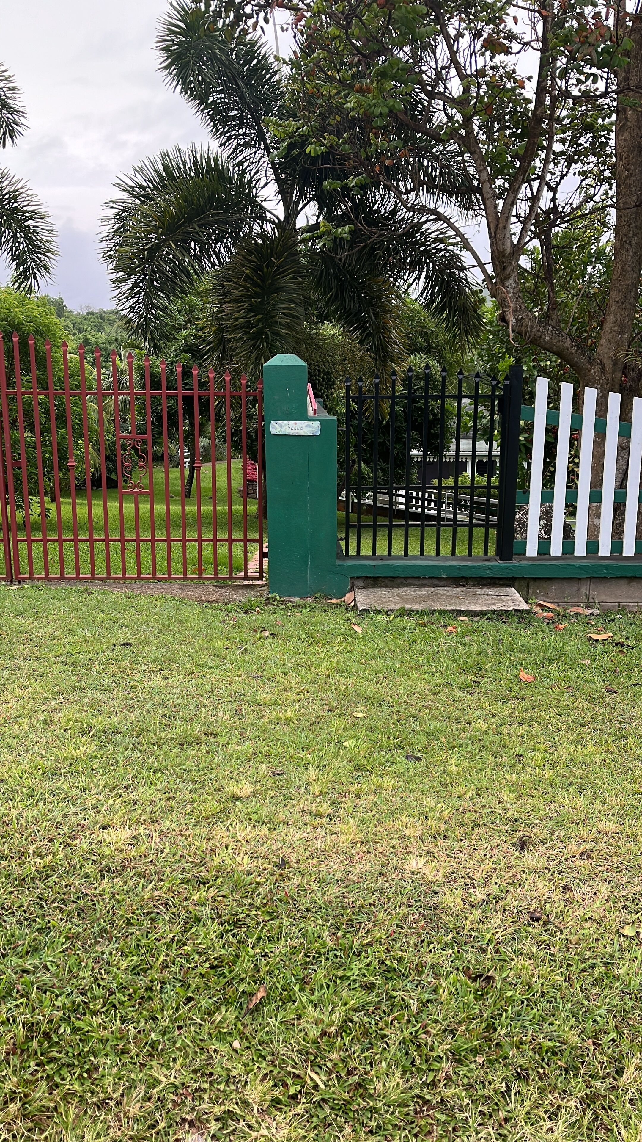 A fenced area with a green utility box and a white picket fence.