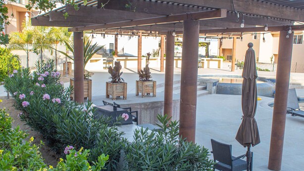 An outdoor patio area with wooden tables, chairs, and a covered seating area. - Private Villa in Gated Community  (Cabo San Lucas)