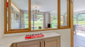 A modern kitchen with a large window, wooden cabinets, and a countertop with a tray.